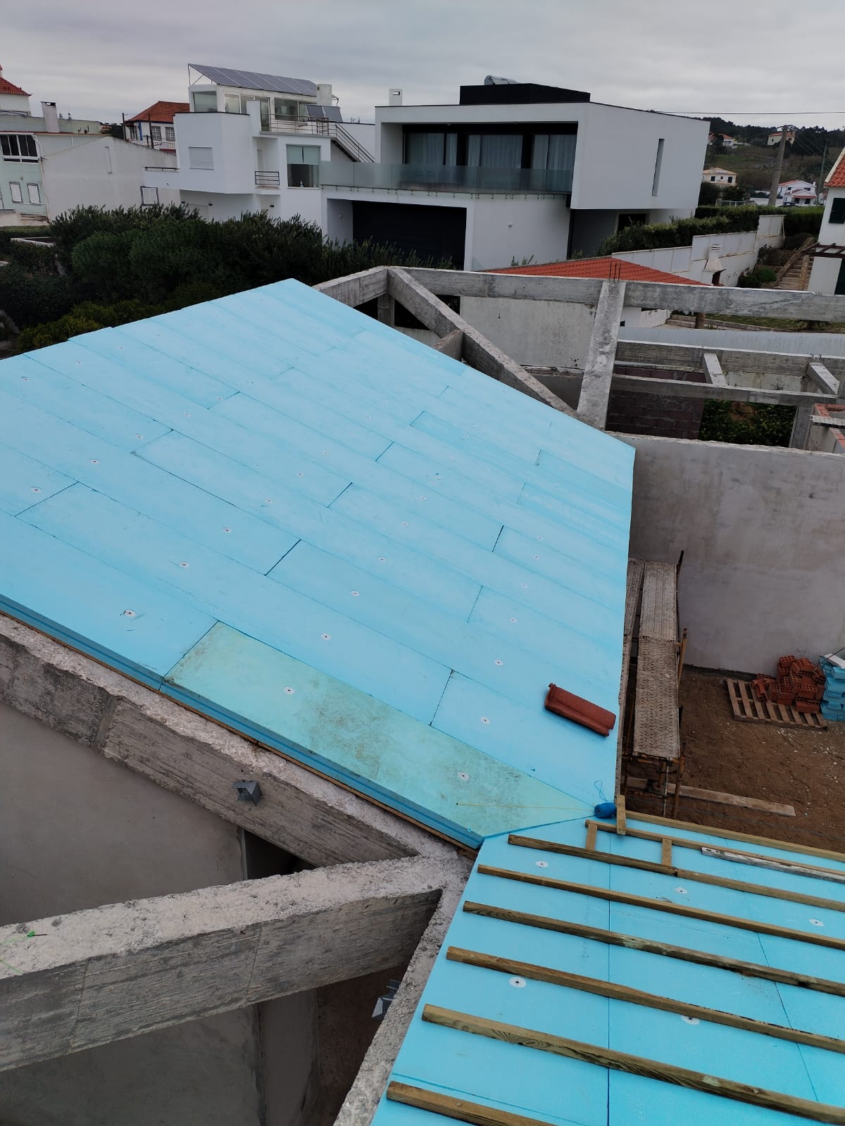 Detalhe do isolamento térmico no telhado com vista para casas modernas